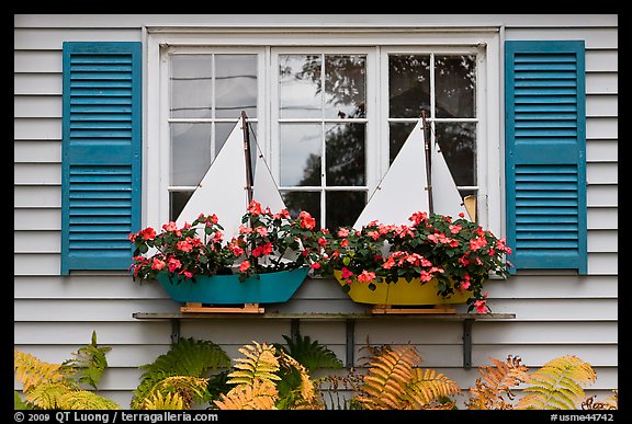 Window with flower pots shaped like sailboats. Bar Harbor, Maine, USA