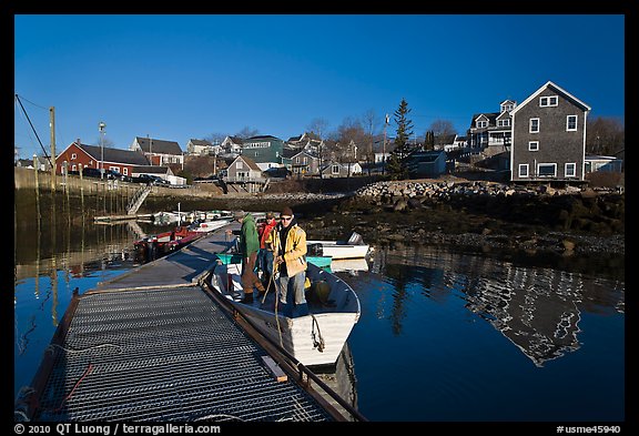 Men preparing to leave on small boat. Stonington, Maine, USA