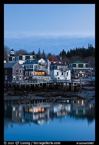 Houses with lights reflected in harbor. Stonington, Maine, USA (color)