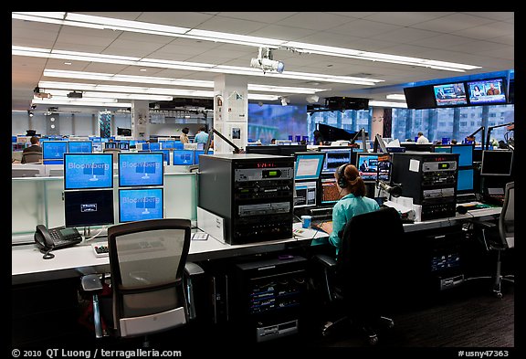 Bloomberg News analyst working in front of many screens. NYC, New York, USA