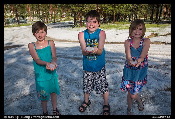 Children in summer dress holding large hailstones, Black Hills National Forest. Black Hills, South Dakota, USA (color)