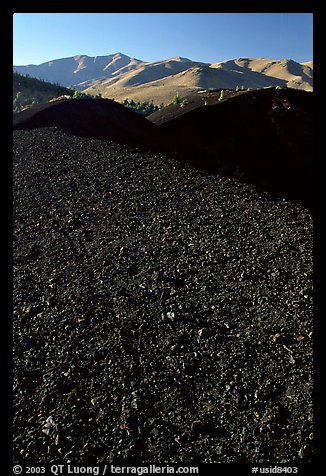Dark pumice, cinder cones, and Pioneer Mountains. Craters of the Moon National Monument and Preserve, Idaho, USA (color)