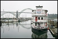 Couple walking on deck next to floating Bed and Breakfast. Newport, Oregon, USA ( color)