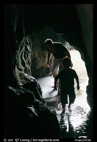 Boy and man exploring sea cave. Bandon, Oregon, USA