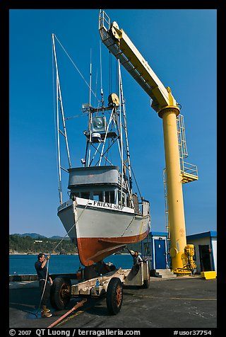 Fishing boat lifted from water by huge hoist, Port Orford. Oregon, USA
