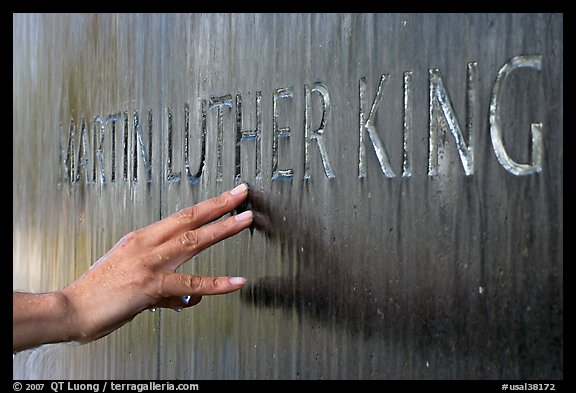 Hand touching the letters Martin Luther King in flowing water. Montgomery, Alabama, USA