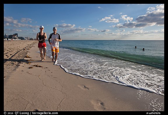Couple jogging on beach,  Miami Beach. Florida, USA (color)