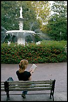 Woman reading a book in front of Forsyth Park Fountain. Savannah, Georgia, USA (color)