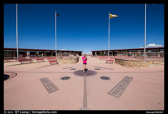 Woman straddling the territory of four states. Four Corners Monument, Arizona, USA (color)