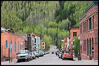 Historic brick buildings and slope with newly leafed aspens. Telluride, Colorado, USA (color)