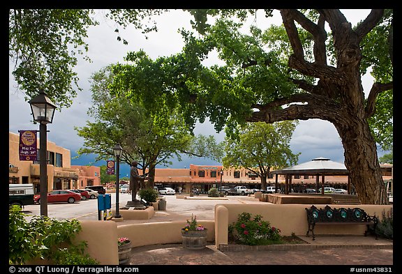 Plazza, trees and buildings in adobe style. Taos, New Mexico, USA