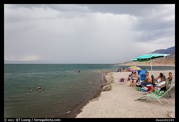 People lounging with beach chairs and umbrellas. Pyramid Lake, Nevada, USA