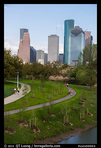 People walking in park with skyline behind. Houston, Texas, USA (color)