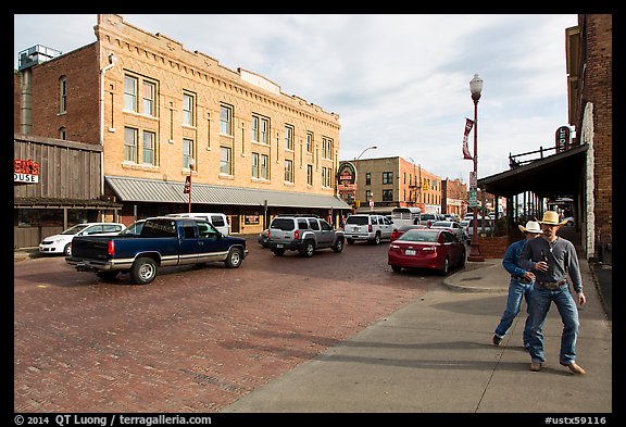 Stokyards street with brick buildings, men with cowboy hats. Fort Worth, Texas, USA (color)