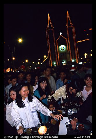 Women on motorbike in front of St Joseph Cathedral on Christmas eve. Ho Chi Minh City, Vietnam