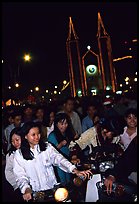 Women on motorbike in front of St Joseph Cathedral on Christmas eve. Ho Chi Minh City, Vietnam