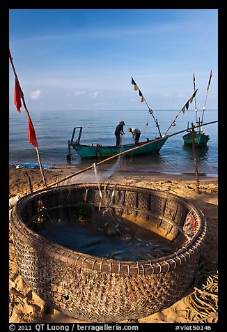Fishermen pulling net out of circular basket. Phu Quoc Island, Vietnam