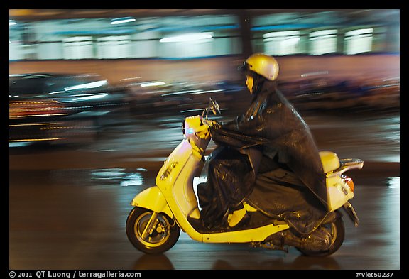 Scooter rider on rainy night. Ho Chi Minh City, Vietnam