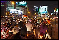 Motorbikes waiting at traffic light at night. Ho Chi Minh City, Vietnam