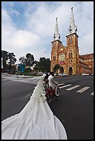 Bride with flowing dress in front of Cathedral. Ho Chi Minh City, Vietnam