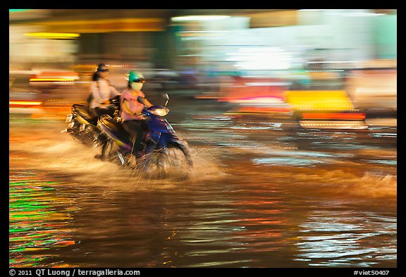 Motorcycle riders, water splashes, and streaks of light. Ho Chi Minh City, Vietnam