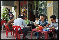 Men eating breakfast on the street. Ho Chi Minh City, Vietnam