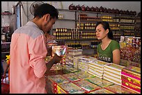 Customer buying box of coconut candy. Ben Tre, Vietnam (color)