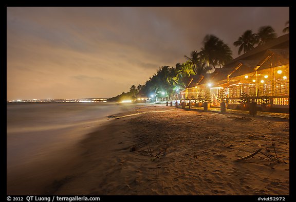 Beach bordered by resorts at night. Mui Ne, Vietnam