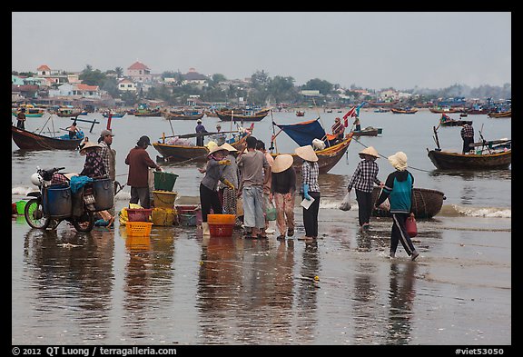 Fishing activity reflected on wet beach. Mui Ne, Vietnam