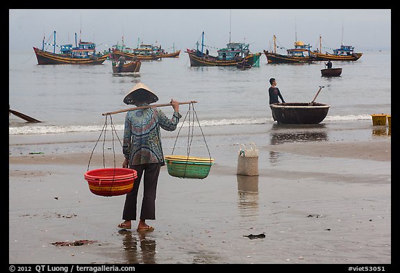 Woman with yoke baskets on beach. Mui Ne, Vietnam (color)