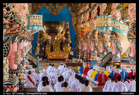 Dignitaries (in colored robes) and other followers praying at the Main hall, Cao Dai temple. Tay Ninh, Vietnam (color)