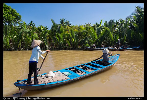 Women row canoes, Phoenix Island. My Tho, Vietnam (color)