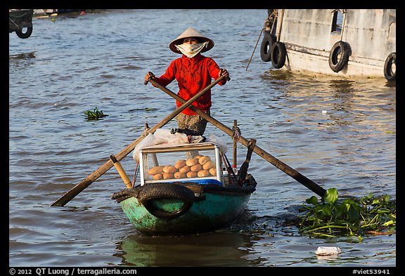 Woman paddling boat with breads, Cai Rang floating market. Can Tho, Vietnam