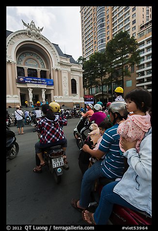 Family on motorbike watching performance at opera house. Ho Chi Minh City, Vietnam (color)