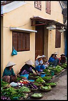 Vegetable vendors sitting in front of old house. Hoi An, Vietnam ( color)