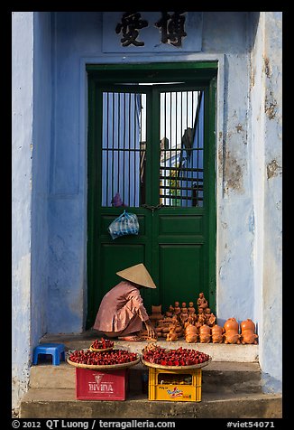 Ceramics vendor, blue temple door. Hoi An, Vietnam