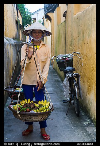 Fruit vendor carrying bananas. Hoi An, Vietnam (color)