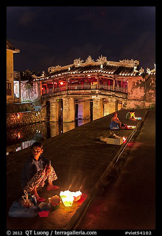 Candle vendors in front of Japanese bridge at night. Hoi An, Vietnam