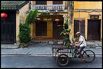 Man riding tricycle cart in front of old townhouses. Hoi An, Vietnam ( color)
