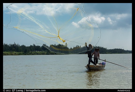 Fisherman throwing net, Thu Bon River. Hoi An, Vietnam