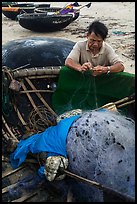 Fisherman repairing net on beach. Da Nang, Vietnam ( color)
