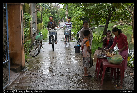 Canalside street with bicyclists and food stand, Thanh Toan. Hue, Vietnam