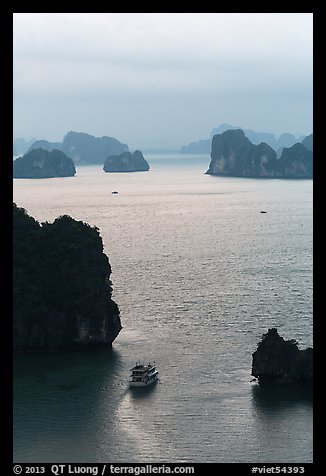 Tour boat navigating between islets. Halong Bay, Vietnam (color)