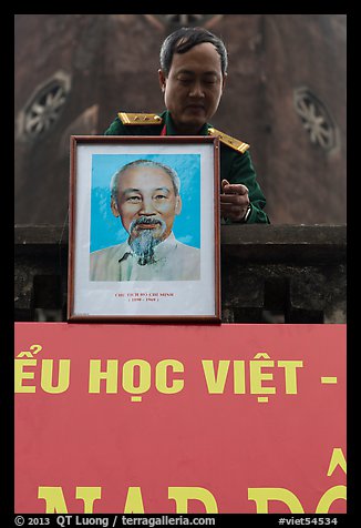 Officer hanging a picture of Ho Chi Minh, Hanoi Citadel. Hanoi, Vietnam