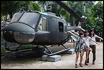 Young women posing with helicopter, War Remnants Museum, district 3. Ho Chi Minh City, Vietnam (color)