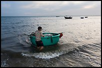 Man holding coracle boat. Mui Ne, Vietnam ( color)