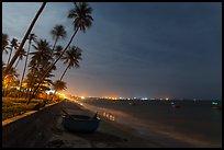 Beach, palm trees and coracle boats at night. Mui Ne, Vietnam (color)