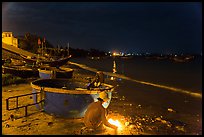 Man with fire next to coracle boat at night. Mui Ne, Vietnam ( color)