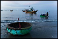 Coracle and fishing boats at dawn. Mui Ne, Vietnam ( color)