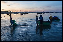 Fishermen using coracle boats to transport cargo at dawn. Mui Ne, Vietnam ( color)